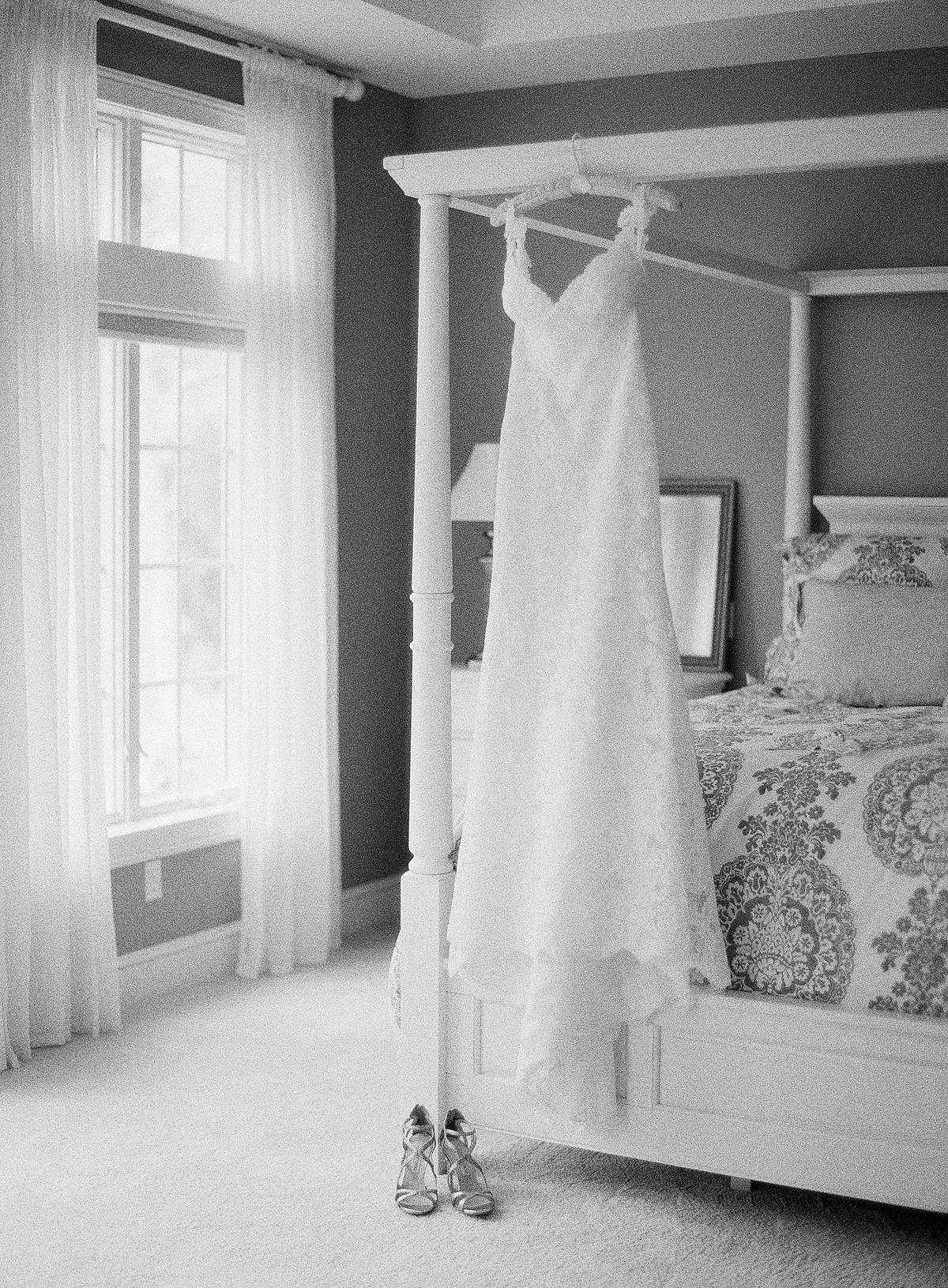 wedding dress hanging on bed